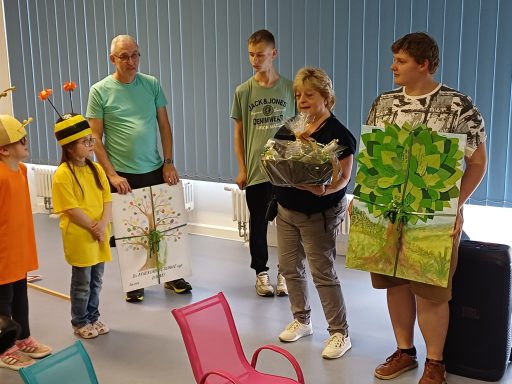 Gruppendynamik mit Teilnehmern, die kreative Kunstwerke und Kostüme präsentieren.