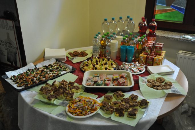 Ein gedeckter Tisch mit verschiedenen Snacks, Süßigkeiten und Getränken.