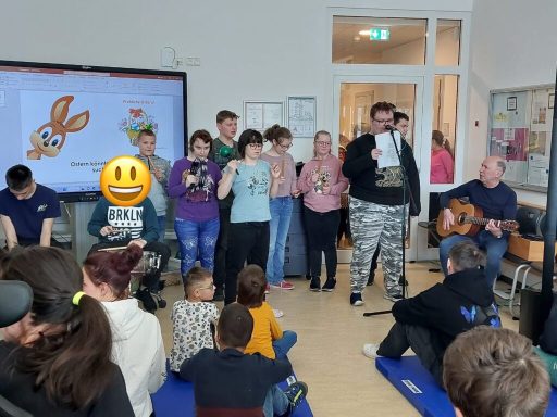 Gruppensitzung mit Menschen, die singen und Musikinstrumente spielen.