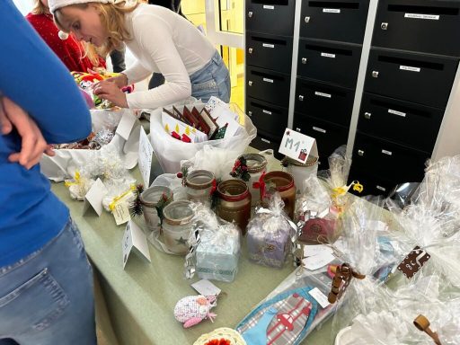 Tisch mit verschiedenen Marmeladen, Süßigkeiten und verpackten Geschenken.