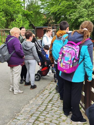 Gruppe von Personen am Geländer, Blick auf eine Aussicht, Kinder mit Kinderwagen.