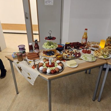 Ein Tisch mit einer Auswahl an Snacks, Obst, Gemüse und Getränken.