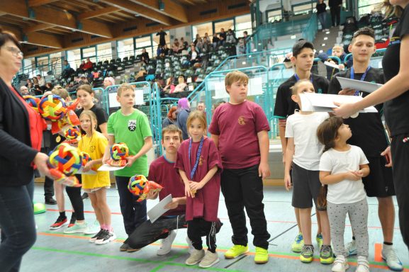 Gruppe von Kindern in Sportkleidung, die bei einer Veranstaltung warten.