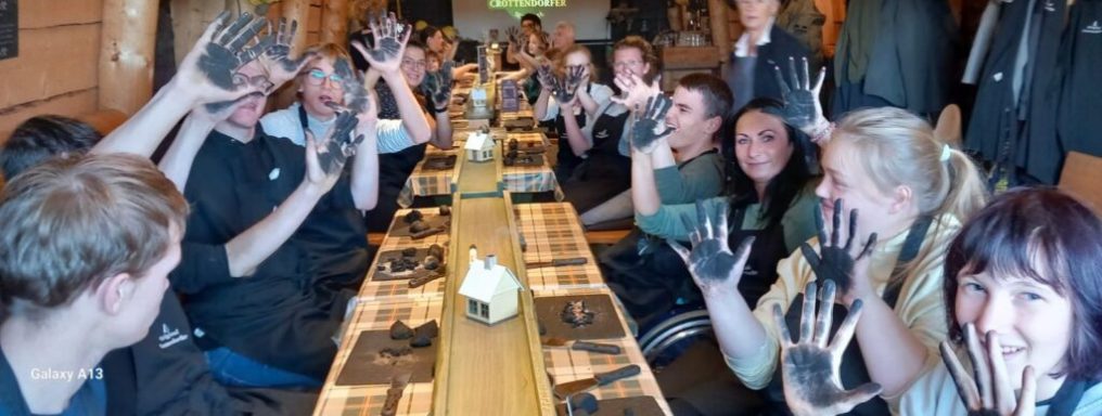 Gruppe von Menschen in einem Restaurant, die ihre verschmutzten Hände stolz präsentieren.