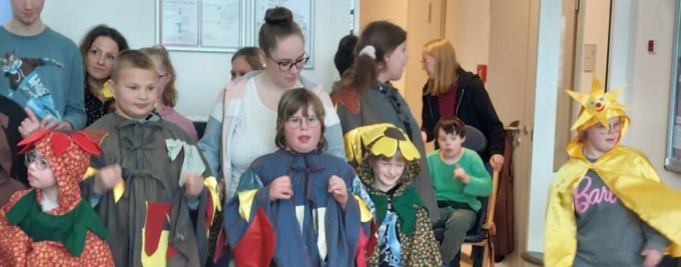 Gruppe von Kindern in Kostümen, die für eine Aufführung bereitstehen.