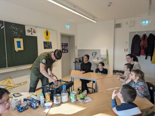Ein Koch zeigt Kindern, wie man eine Mahlzeit zubereitet, in einem Klassenzimmer.