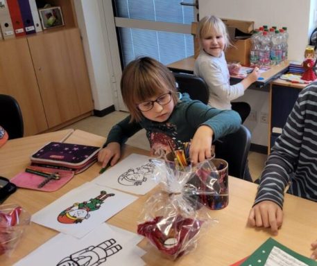 Kinder arbeiten an Bastelprojekten, mit Zeichnungen und Material auf dem Tisch.