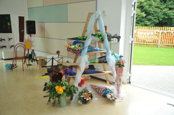 Dekorierte Treppe mit bunten Blumen und Festmaterialien in einem hellen Raum.
