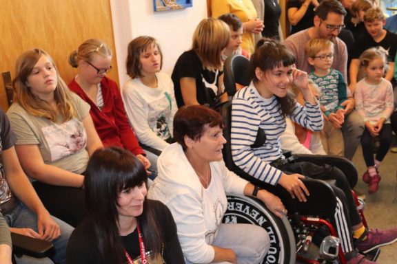 Eine diverse Gruppe von Menschen sitzt zusammen in einem Raum.