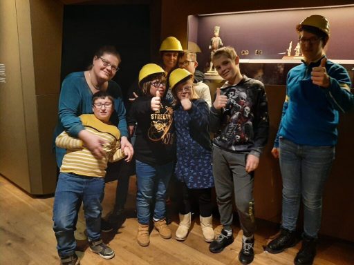 Eine Gruppe von sieben Personen, die gelbe Helme tragen und lächeln.