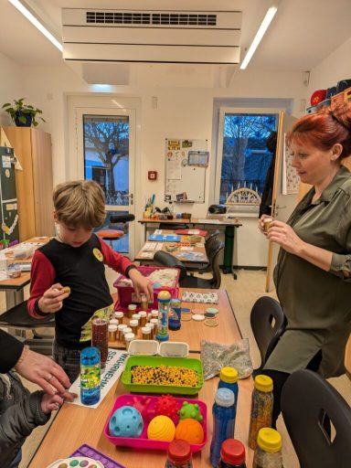 Kinder arbeiten mit Farben und Materialien in einem kreativen Raum.