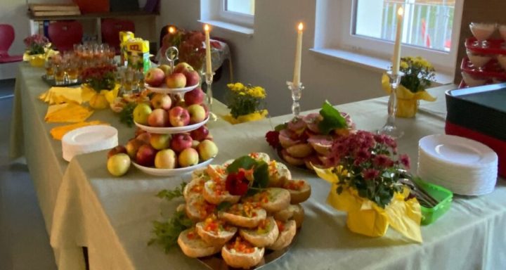 Festlich gedeckter Tisch mit verschiedenen Speisen, Obst und Kerzen auf einem Tisch.