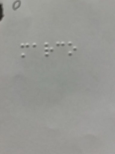 Zwei Zeilen mit Braille-Schrift auf einem hellen Hintergrund.