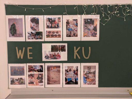 Eine Pinnwand mit Fotos und dem Text "WE KU" in der Mitte.