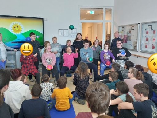 Gruppensitzung mit Kindern und Jugendlichen, die aktiv teilnehmen und lächeln.