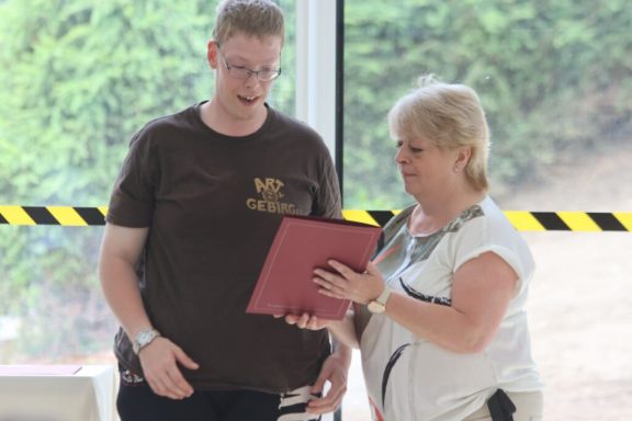 Zwei Personen betrachten gemeinsam Dokumente in einem hellen Raum.