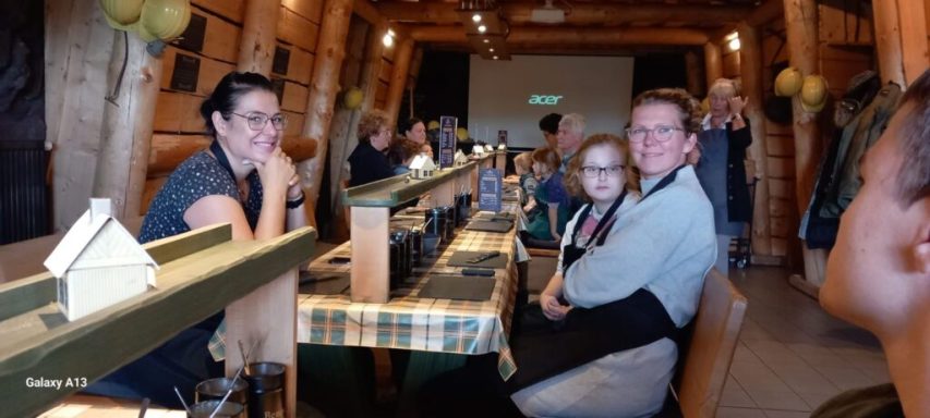 Gruppenszene in einem Holzrestaurant, Gäste an Tischen, entspannte Atmosphäre.