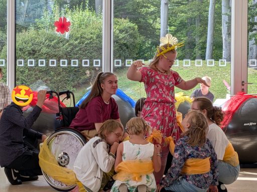 Eine fröhliche Versammlung von Kindern und Erwachsenen bei einer Feier im Freien.