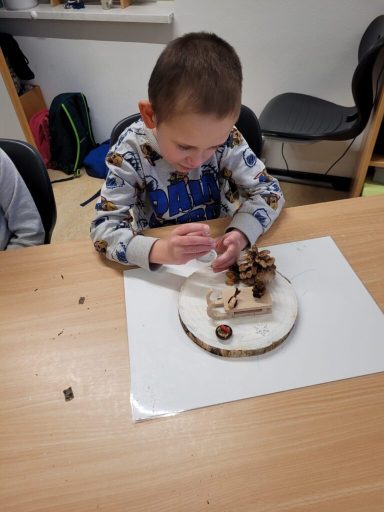 Ein Junge arbeitet an einem Holzprojekt auf einem Tisch.