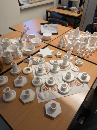 Verschiedene weiße Kunststoffformen und Objekte auf einem Tisch arrangiert.