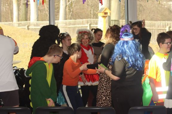 Gruppe von bunt kostümierten Personen in einer festlichen Umgebung.