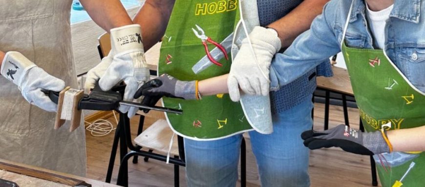 Hände, die zusammenarbeiten, um ein Projekt mit Werkzeug und Materialien zu gestalten.