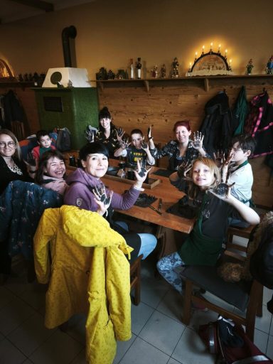 Eine Gruppe von Personen an einem Tisch mit Getränken, gemütliche Atmosphäre.