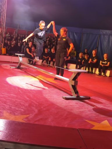 Zwei Künstler führen eine Akrobatik-Nummer auf einem Hochseil im Zirkus vor.