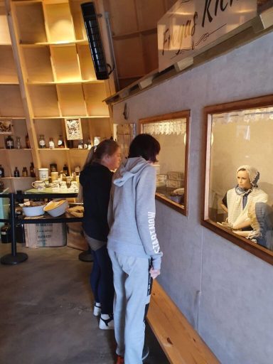 Zwei Personen betrachten einen Glasausschnitt in einem gemütlichen Raum.