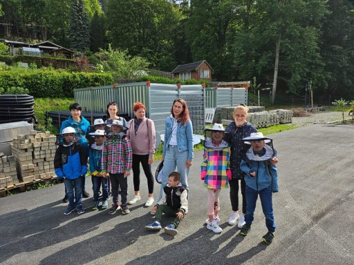 Gruppe von Kindern und Erwachsenen, die sich im Freien auf einem Weg versammeln.