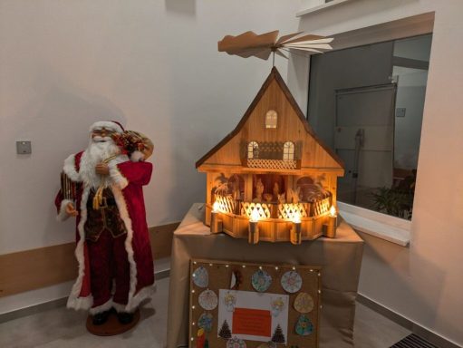 Weihnachtliche Dekoration mit einem großen Lebkuchenhaus und einem Weihnachtsmann.