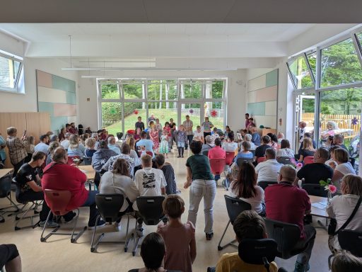 Vielzahl von Menschen in einem Raum, versammelt für eine Veranstaltung oder Versammlung.