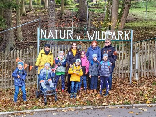 Gruppe von Kindern und Erwachsenen vor dem Eingang zum Natur- und Wildpark.