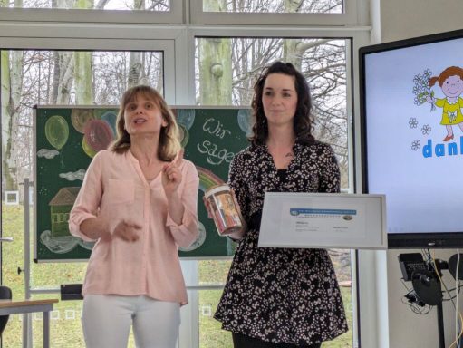 Zwei Frauen präsentieren ein Produkt vor einer Tafel in einem modernen Konferenzraum.