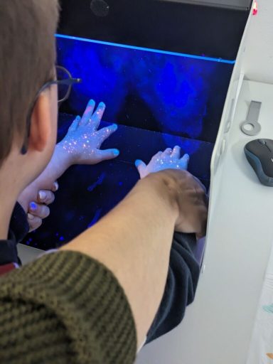 Zwei Hände auf einem Bildschirm mit bläulichem Licht und Berührungspunkten.