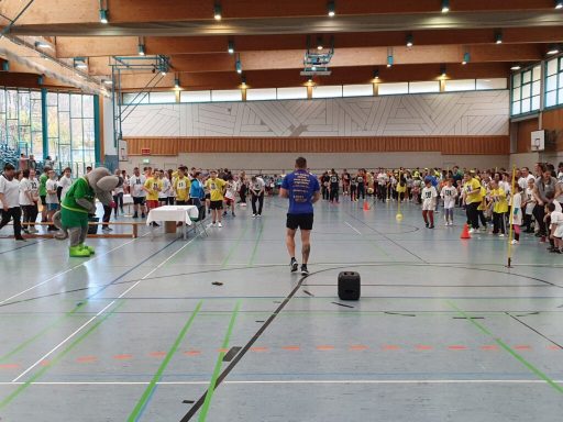 Ein Sportevent in einer Halle mit vielen Teilnehmern und verschiedenen Aktivitäten.