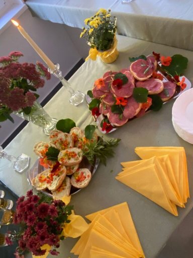 Festlich gedeckter Tisch mit Häppchen, Blumen und Kerzen.