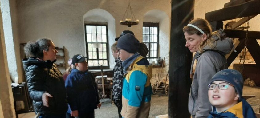 Eine Gruppe von fünf Personen unterhält sich in einem historischen Raum.