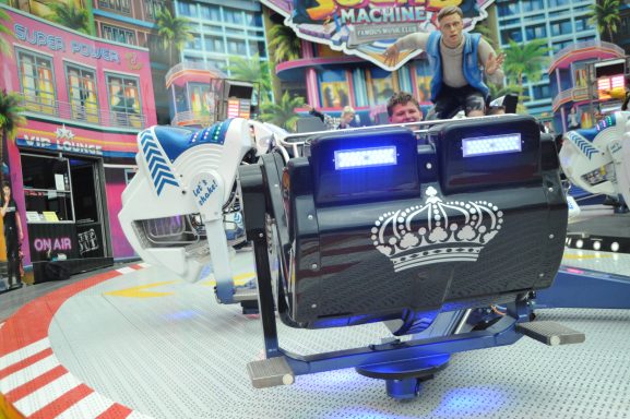 Fahrgeschäft mit drehenden Sitzen und bunten Hintergrund, Menschen haben Spaß.