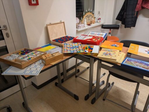 Eine Ansammlung von verschiedenen Brettspielen und Spielmaterialien auf Tischen.