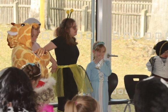 Kinder in Kostümen stehen auf einer Bühne während einer Aufführung.