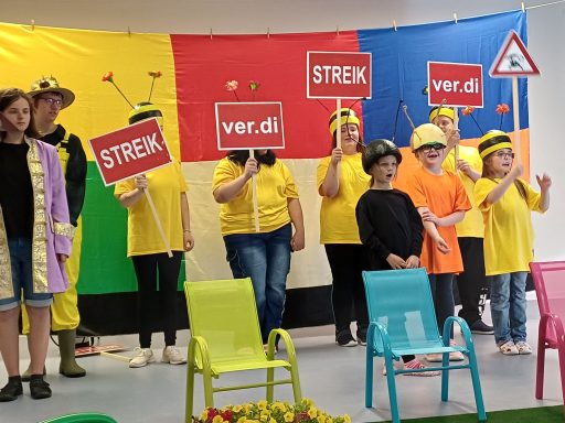 Gruppendarstellung mit Menschen in gelben Shirts und Schildern für einen Streik.