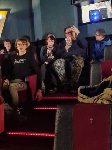 Eine Gruppe von Menschen sitzt im Kino, einige klatschen, andere schauen gespannt.