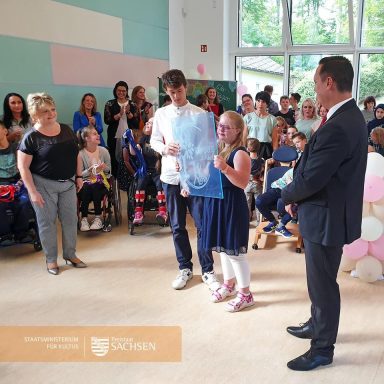 Gruppenevent mit Kindern und Erwachsenen, einige applaudieren und erfreuen sich.