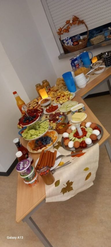 Ein Tisch mit verschiedenen Lebensmitteln, Snacks und Getränken in einer gemütlichen Anordnung.