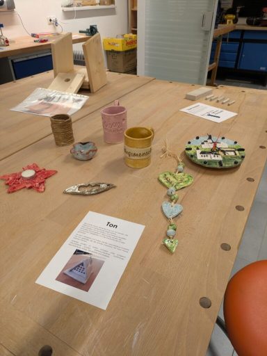 Bunte handgefertigte Objekte und Schmuck auf einem Tisch in einem kreativen Raum.