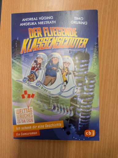 Buchcover "Der fliegende Klassenschüler" mit einem Comic-Stil und drei Charakteren.