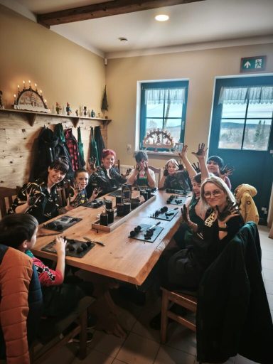 Eine Gruppe von acht Personen sitzt um einen Tisch in einem gemütlichen Raum.