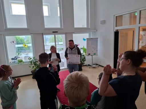 Gruppendiskussion in einem hellen Raum, Menschen präsentieren Plakate.